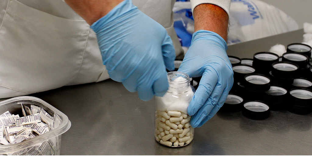 Vireo technician filling bottle of capsules