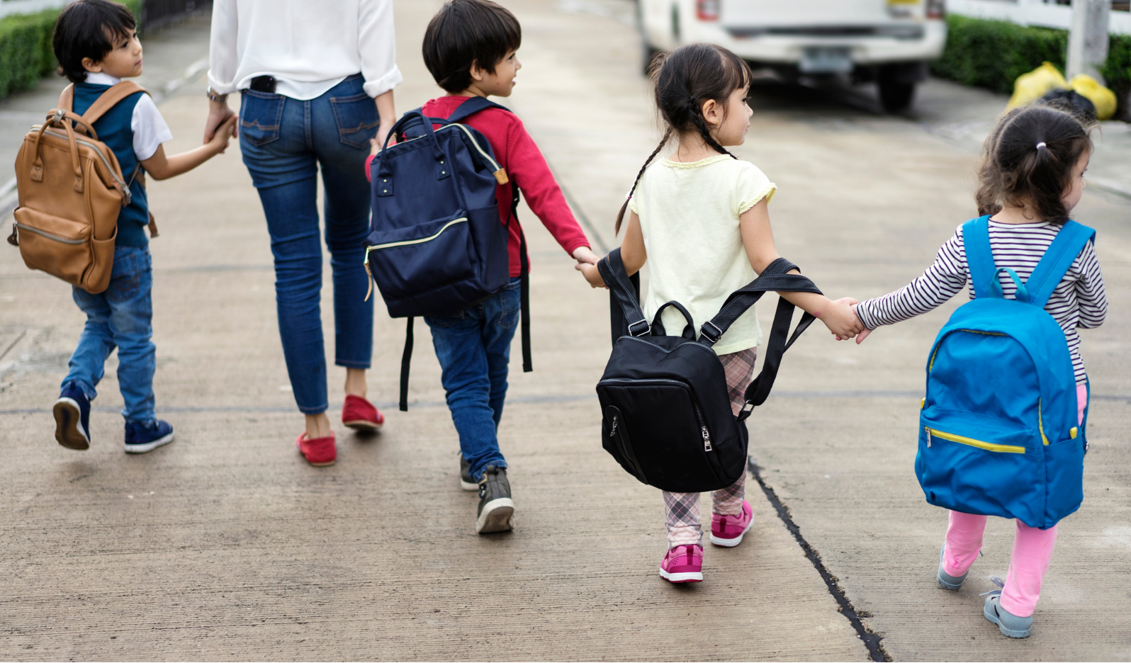 Women_four_kids woman walking hand-in-hand with four young children