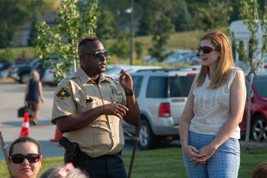 An Elite Tactical security guard chats with a member of the community at an event.