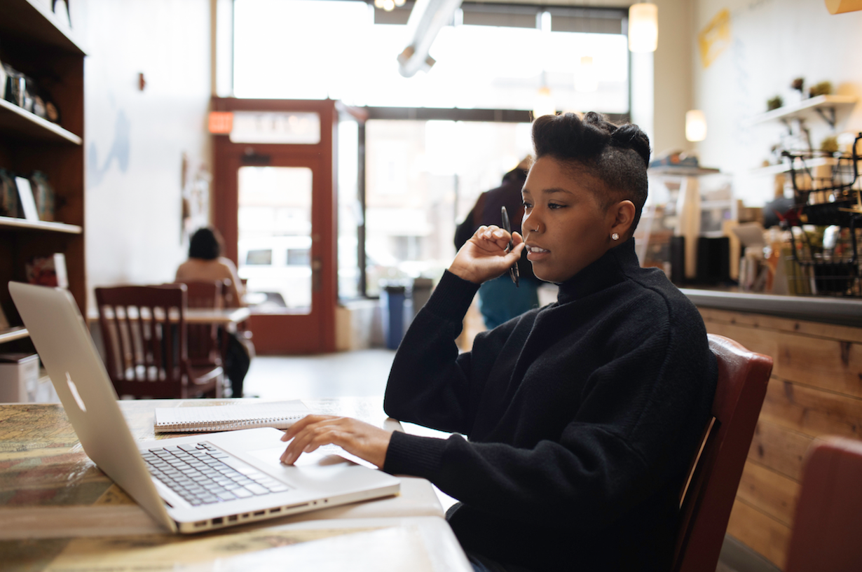 A young entrepreneur at work on her laptop in a coffee shop.