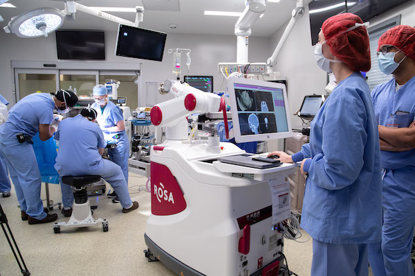 A team of Children's Hospital surgeons uses high-tech equipment in an operating room.