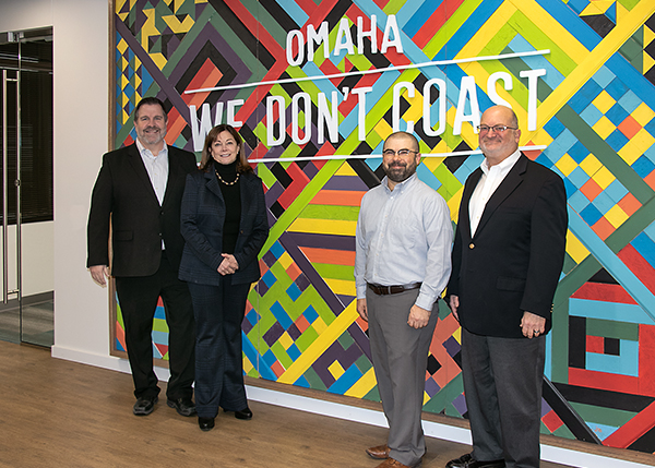 Three current Chairman's Award winners pose in front of the Greater Omaha Chamber logo.